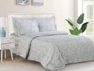 Grey duvet set with a white scrolling-swirl pattern and matching shams on a bed