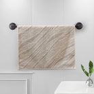 Sand terry hand towel with a woven diagonal wave-stripe pattern on a bar