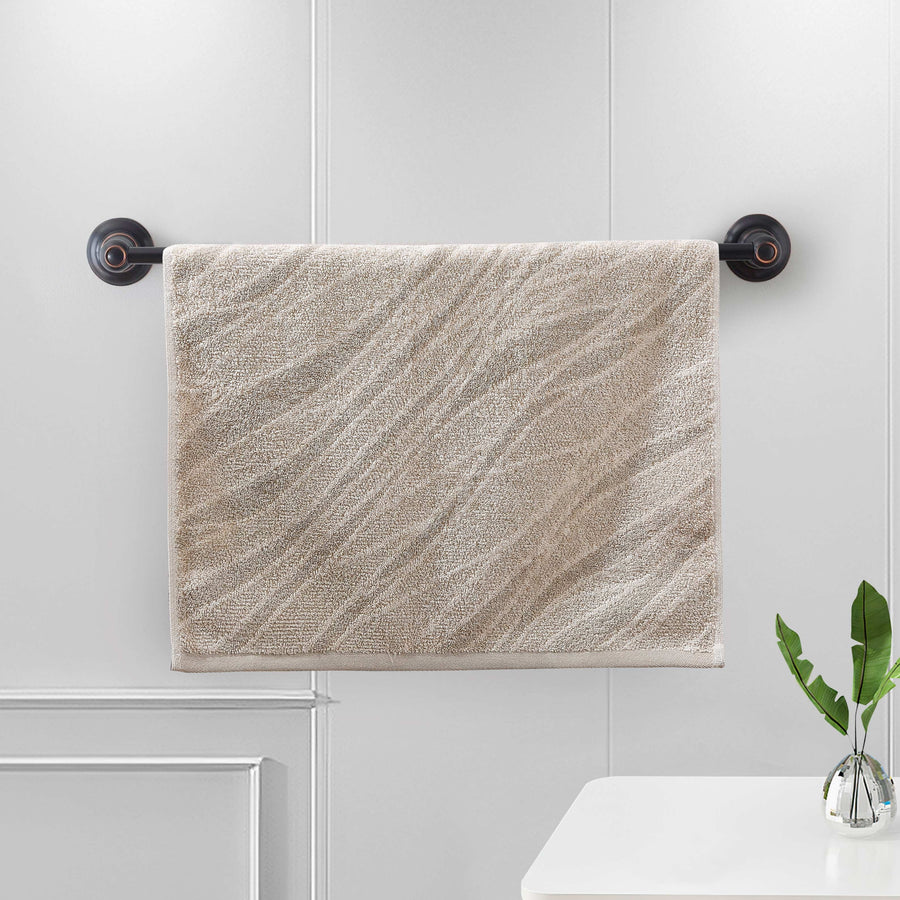 Sand terry hand towel with a woven diagonal wave-stripe pattern on a bar