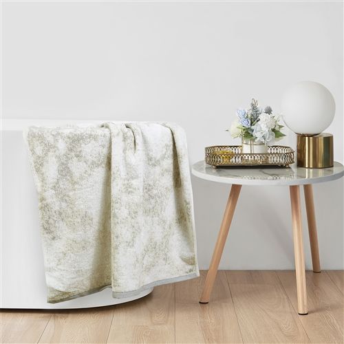 Grey marbled terry hand towel draped over the edge of a bathtub