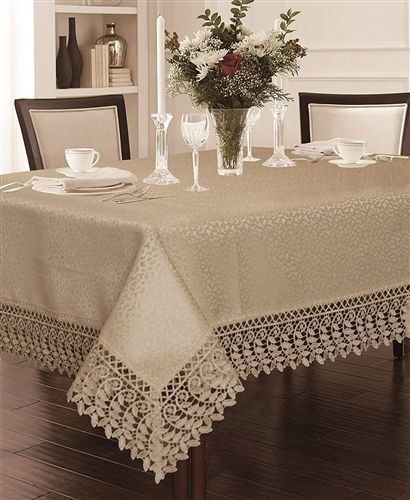 White damask tablecloth with a deep macramé lace border and corner medallions, set on a dining table