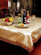 Ivory-gold damask tablecloth with a tone-on-tone medallion weave and a gold bullion tassel fringe