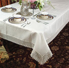 Ivory damask tablecloth with a deep white crochet lace border and fringe on a set table