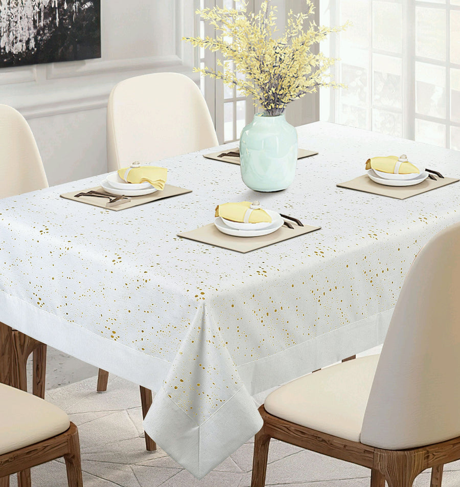 White tablecloth scattered with a gold metallic fleck-splatter print, set for dinner
