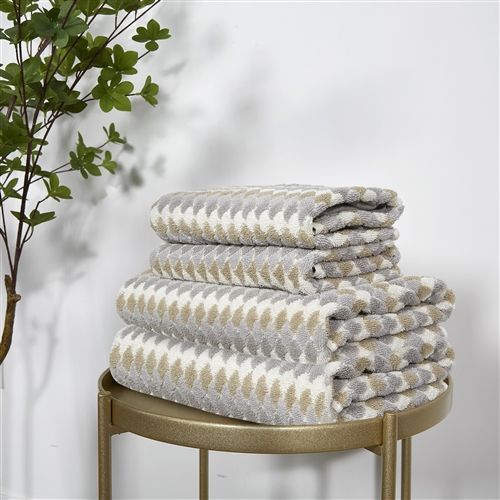 Taupe and grey terry towels woven with a small stacked-petal geometric, folded in a stack