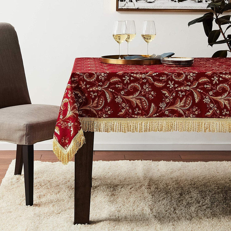 Burgundy damask tablecloth with a gold Jacobean vine pattern and gold tassel fringe