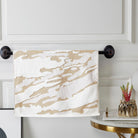 Gold and white woven terry hand towel with a cloudy marbled jacquard, on a black towel bar