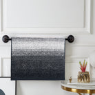 Ombré terry hand towel shading from white to black, hanging on a black towel bar