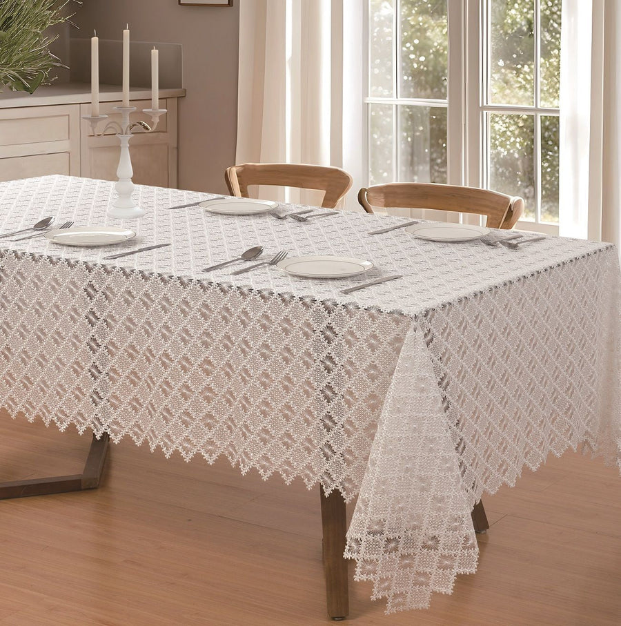 White diamond-lattice lace tablecloth with floral rosettes and a scalloped edge on a dining table