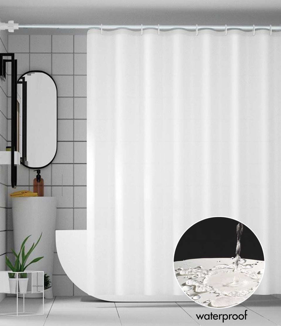 White fabric shower curtain liner hanging on a rod in a tiled bathroom