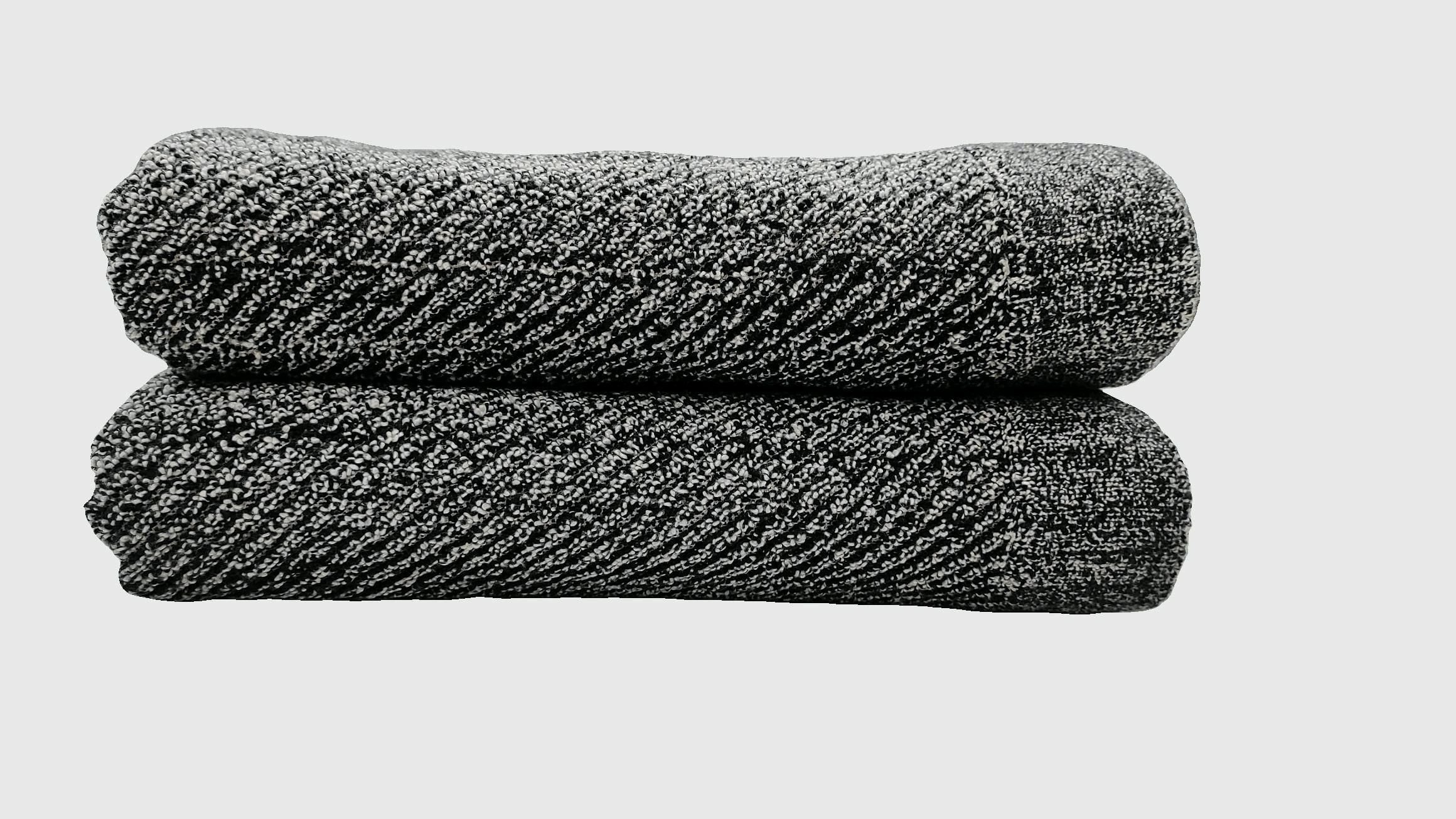 Folded black terry towels with a diagonal ribbed weave