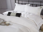 White waffle-textured cotton sateen duvet set with matching shams on a metal bed