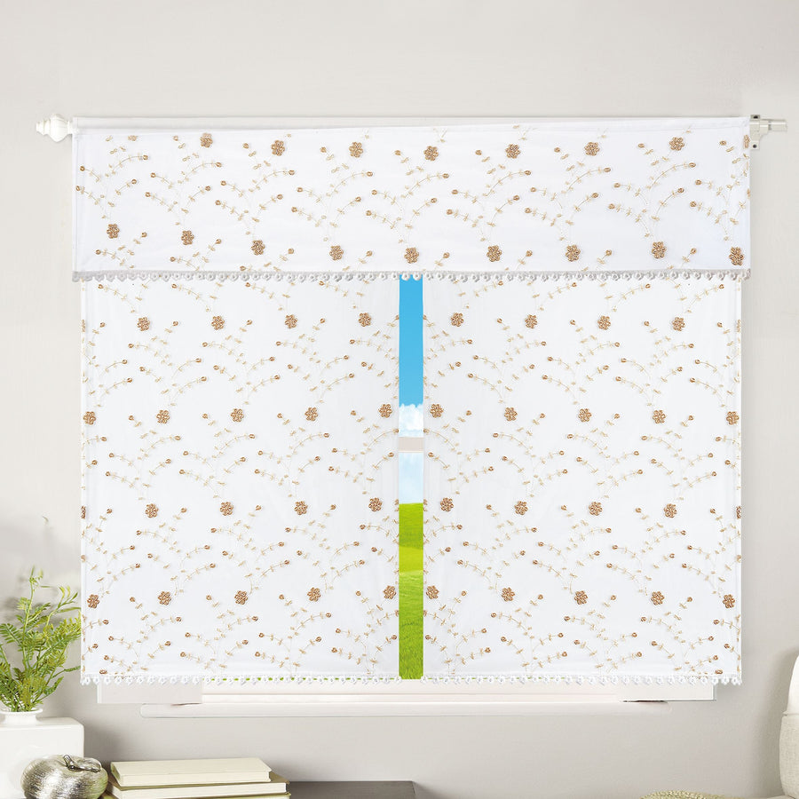 White sheer window curtain and valance embroidered with gold floral vines and a pompom trim
