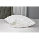 White zippered cotton pillow protector on a bed