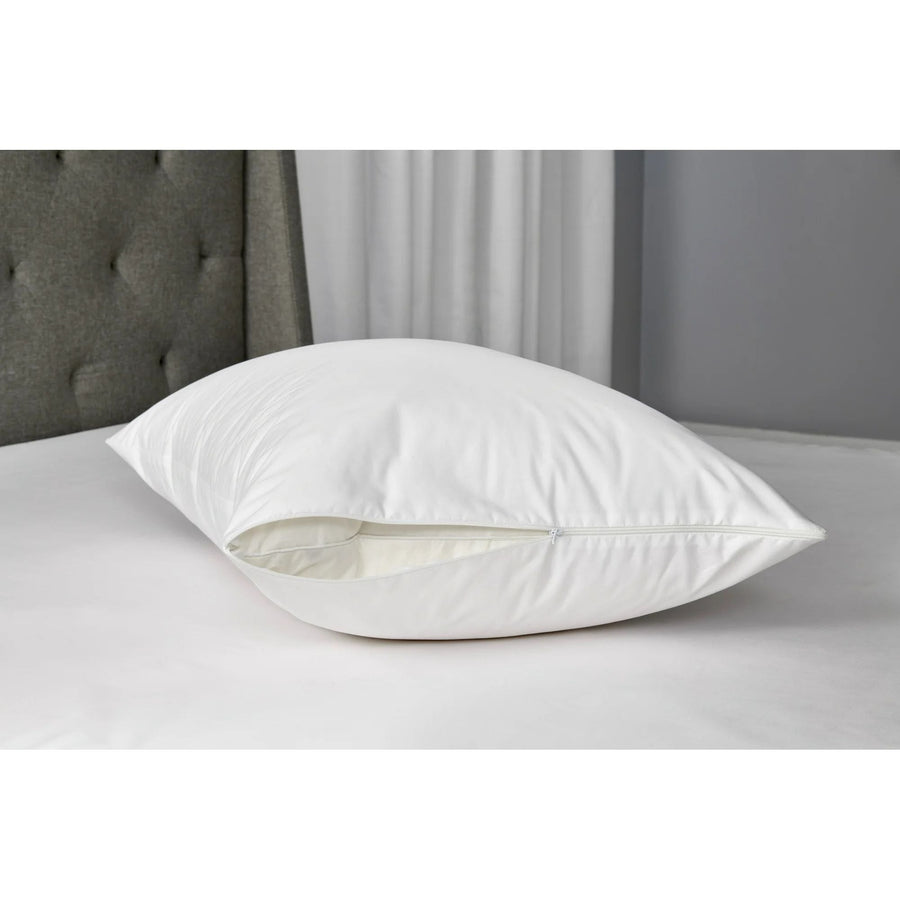 White zippered cotton pillow protector on a bed