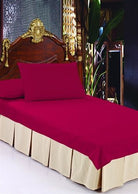Sand box-pleat tailored bed skirt beneath a red fitted sheet on a bed