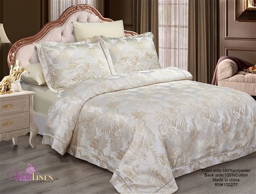 Champagne satin-jacquard duvet set with a gold palm-leaf pattern and matching pillow shams on a bed