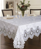 White lace tablecloth with a damask floral field and deep scalloped floral border on a dining table