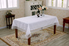 White lace tablecloth with allover floral scrollwork and a deep crochet fringe border