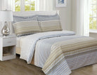 Cotton duvet set in horizontal blue, taupe and cream stripes with small geometric bands, on a bed
