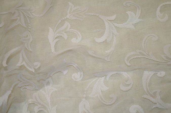 Embroidered sheer fabric with floral patterns in soft beige tones.